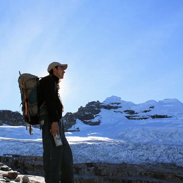 Caminante de espaldas contemplando la majestuosidad de la montaña.