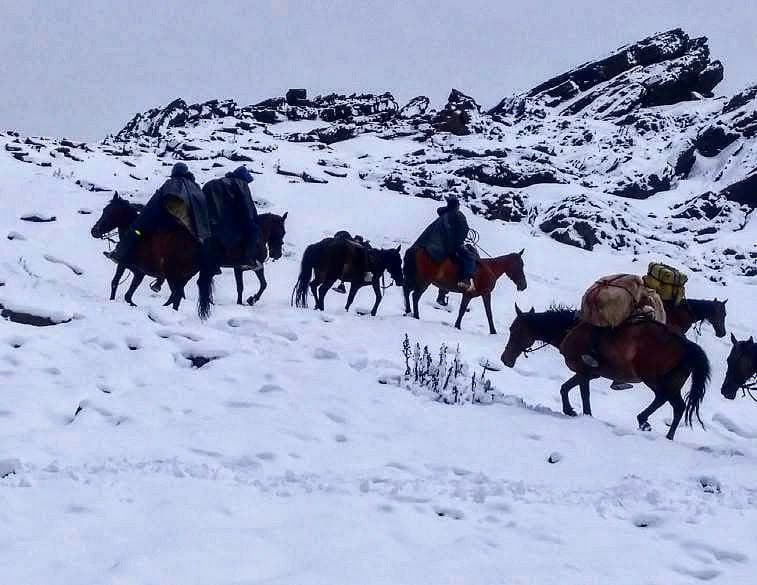 Antiguo grabado rupestre en una roca con paisaje montañoso.